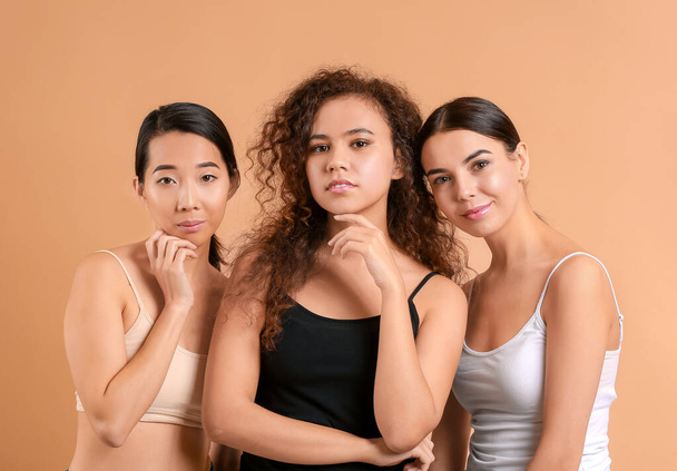 Schöne junge Frauen mit gesunder Haut auf farbigem Hintergrund - Foto, Bild