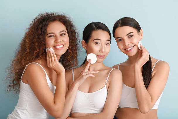 Beautiful young women with cotton pads on color background - Photo, Image