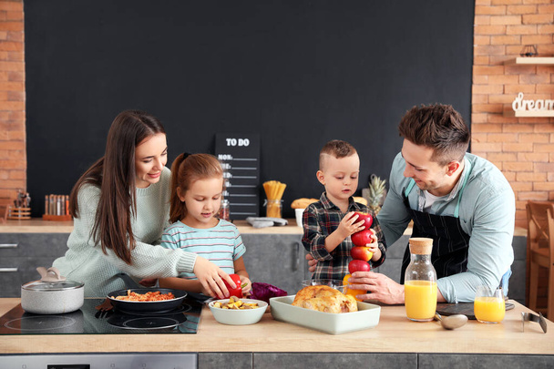 Young family cooking together in kitchen - Foto, Imagen