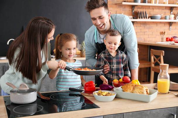 Jeune famille cuisine ensemble dans la cuisine
 - Photo, image
