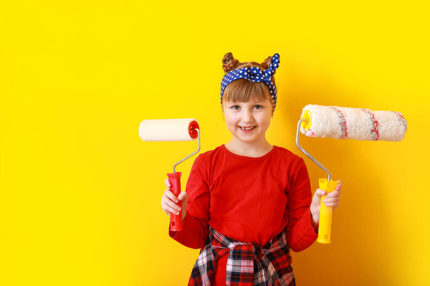 Petite fille avec des rouleaux de peinture près du mur de couleur
 - Photo, image