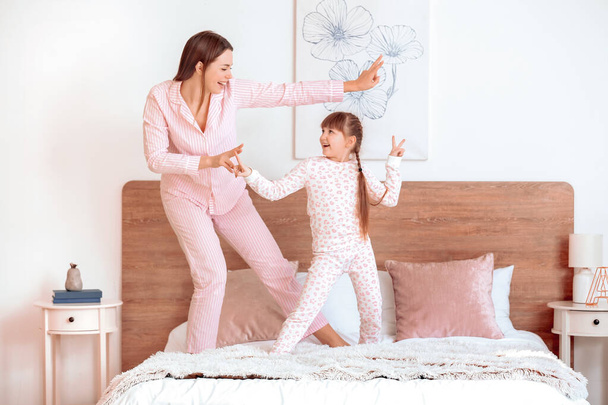 A boldog anya reggele és a kislánya táncol a hálószobában - Fotó, kép