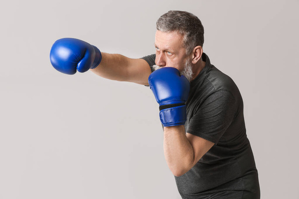 Sportowy starszy bokser na szarym tle - Zdjęcie, obraz