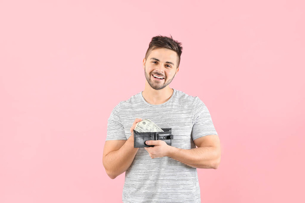 Happy man with purse on color background - Foto, Bild