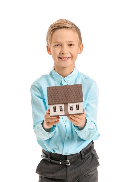 Portrait of little real estate agent with model of house on white background - Фото, изображение