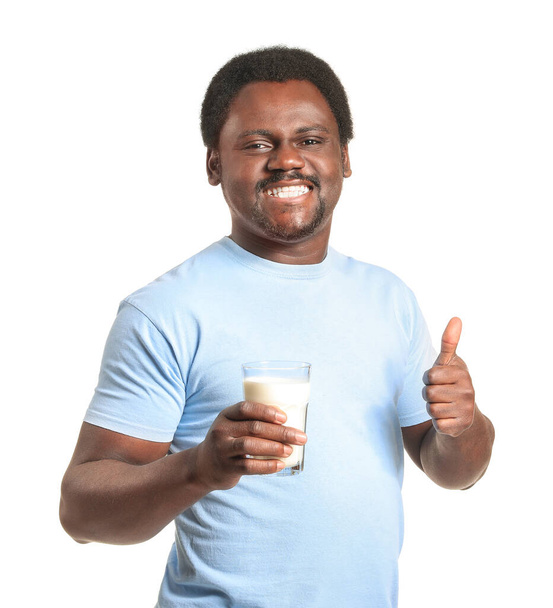 Sütlü genç Afro-Amerikalı adam beyaz arka planda baş parmağını kaldırıyor - Fotoğraf, Görsel