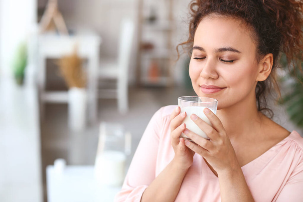 Fiatal afro-amerikai nő tejet iszik otthon - Fotó, kép