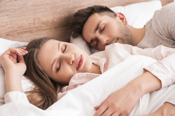 Young couple sleeping in bed - Valokuva, kuva