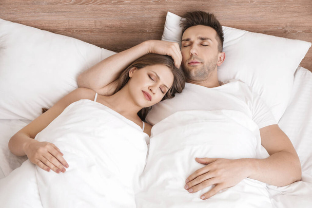 mladý pár spí v posteli - Fotografie, Obrázek