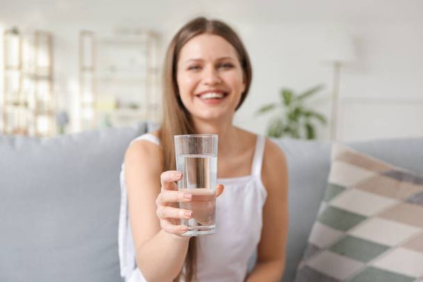 Красива молода жінка п'є воду вдома
 - Фото, зображення