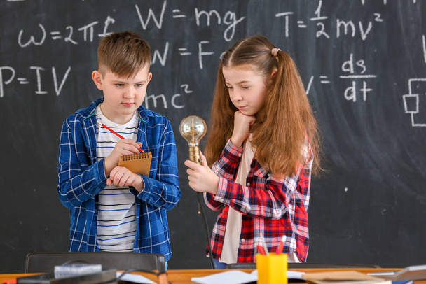 Cute little children at physics lesson in classroom - Foto, imagen