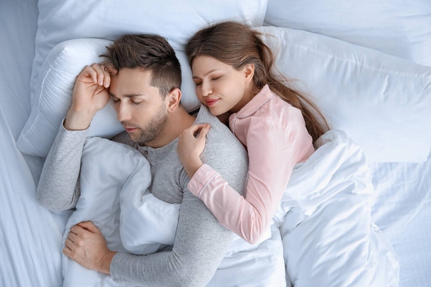 молодая пара спит в постели - Фото, изображение