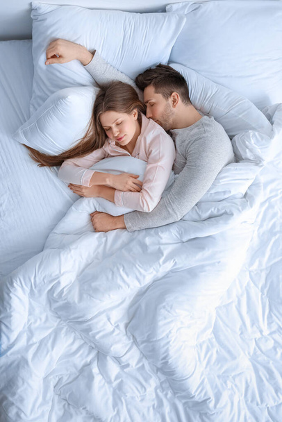 Young couple sleeping in bed - Fotó, kép