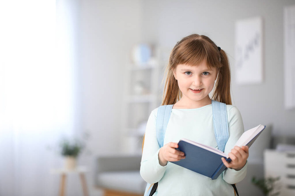 Aranyos kis iskoláslány könyvvel otthon - Fotó, kép