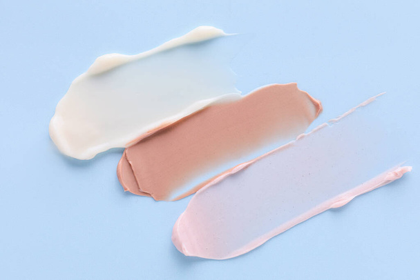 Samples of cream on color background - Fotoğraf, Görsel