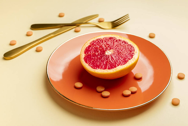 Plate with weight loss pills and grapefruit on color background - Valokuva, kuva
