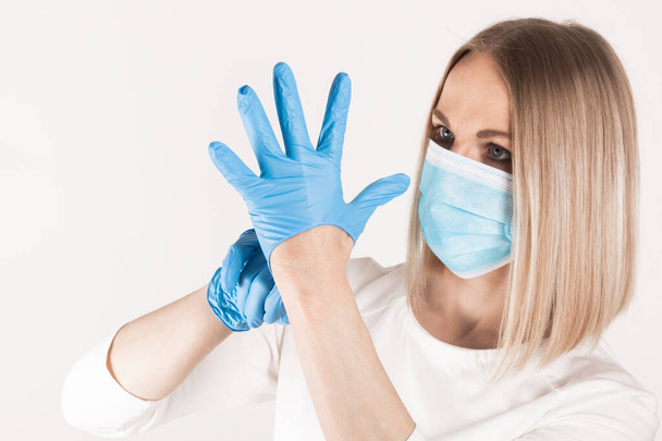Woman puts on medical gloves close up. - Photo, image
