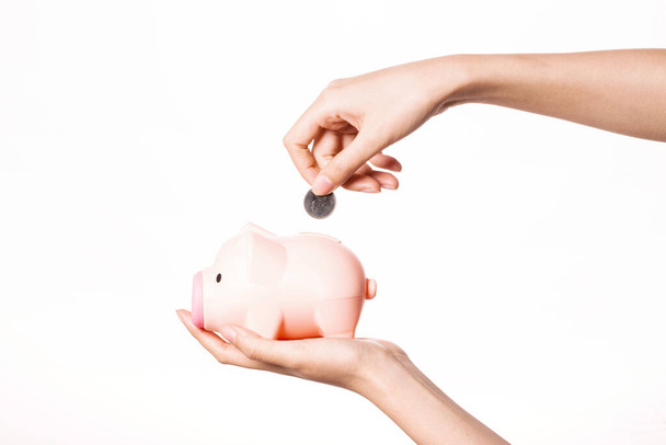 Woman hand hold a piggy bank with coin isolated on white. - Foto, imagen