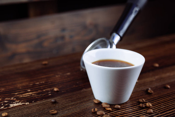Una taza de café negro y portafiltros de espresso. - Foto, Imagen