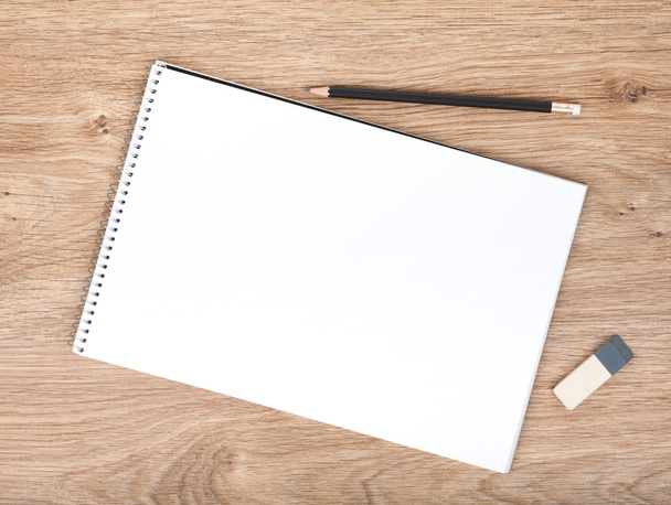 Bloc de notas en blanco, lápiz y borrador en la mesa de madera
 - Foto, imagen
