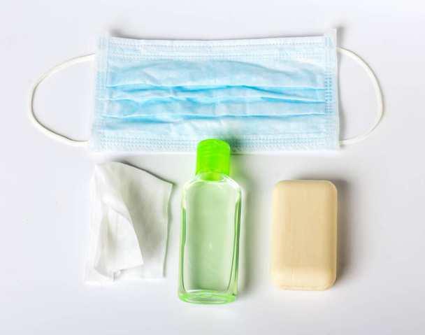Düz Coronavirus önleme antibakteriyel mendiller sabun ve dezenfekte jeli ve beyaz arka planda virüse karşı tıbbi maske. - Fotoğraf, Görsel