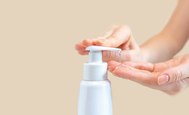 Een vrouwtje drukt op een fles met antibacteriële gel om de handen van bacteriën en virusclose-up schoon te maken en te wassen. Concept van bescherming en profylaxe tegen coronavirusziekte. - Foto, afbeelding