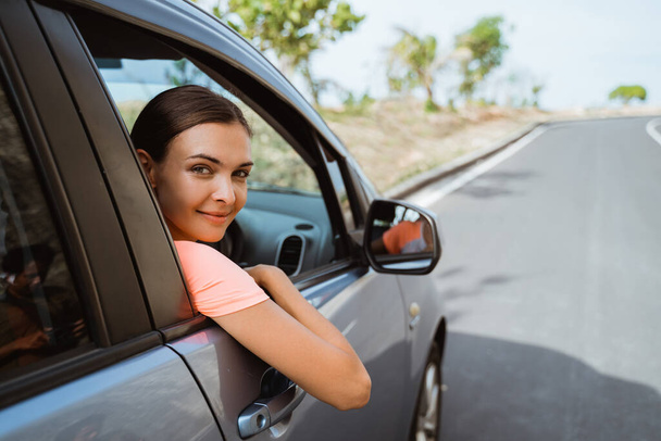 mujer sonriendo mientras está sentada en su coche
 - Foto, Imagen