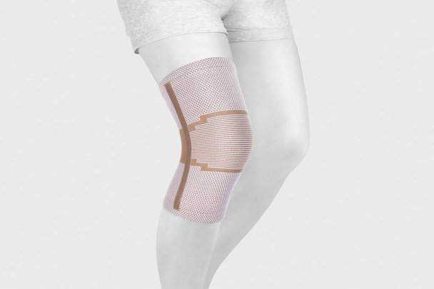 Knee Support Brace on leg isolated on white background. Orthopedic Anatomic Orthosis. Braces for knee fixation, injuries and pain. Orthotics. Foot orthosis. Knee Joint Bandage Sleeve. Elastic Sports  - Foto, imagen
