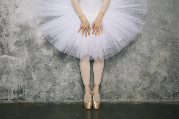 Όμορφη νεαρή χορεύτρια μπαλαρίνα χορεύει κλασικό μπαλέτο ενάντια ρουστίκ τοίχο - Φωτογραφία, εικόνα
