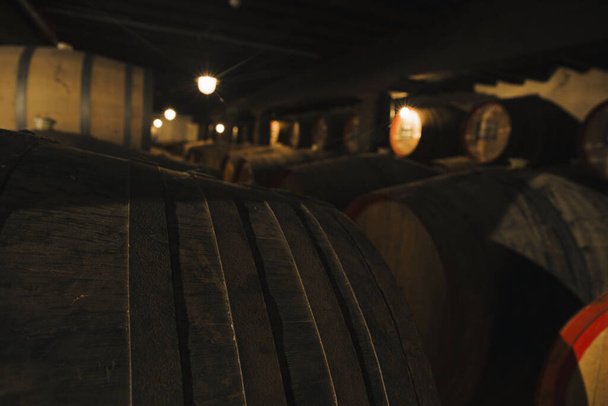 Вид на вино в дерев'яних бочках, що зберігаються для старіння в підвалі
 - Фото, зображення