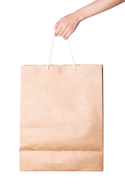 Vrouw hand houden een ambachtelijke boodschappentas geïsoleerd op wit. - Foto, afbeelding