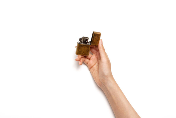 Woman hand hold a vintage lighter isolated on white. - 写真・画像