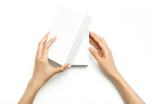 Kobieta ręka trzymać pakiet smartfon odizolowany na białym. - Zdjęcie, obraz
