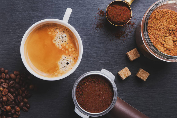 ブラックコーヒー、エスプレッソメーカーのフィルターホルダーと散乱ローストコーヒー豆 - 写真・画像