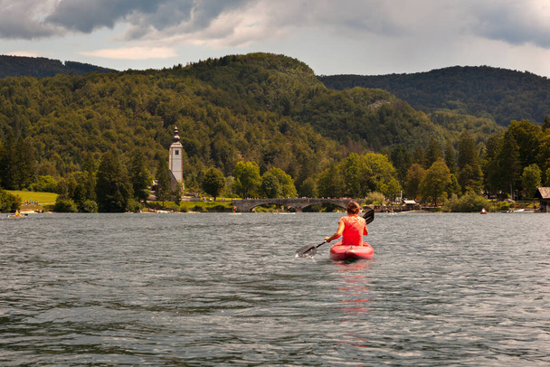 Lány kajakozás a festői Bohinj-tó, Szlovénia - Fotó, kép