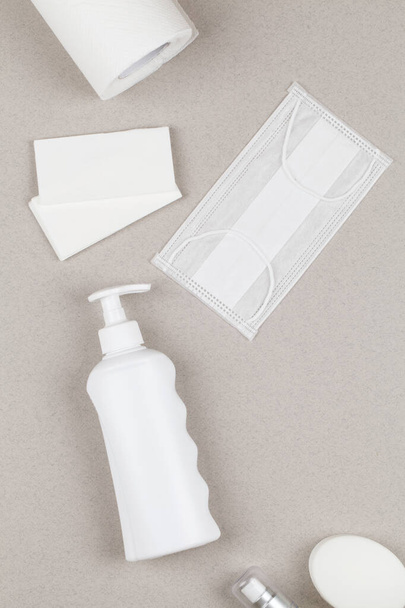 Antiseptic gel, sanitary napkins, medical mask, antibacterial gel, soap on gray background. Personal protective hygiene concept. Prevention of coronavirus disease COVID-19 - Photo, Image