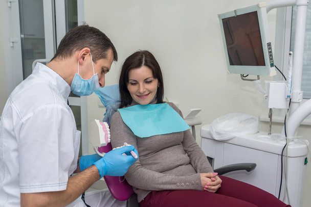 Mujer en odontología señalando muestreador de dientes
 - Foto, imagen