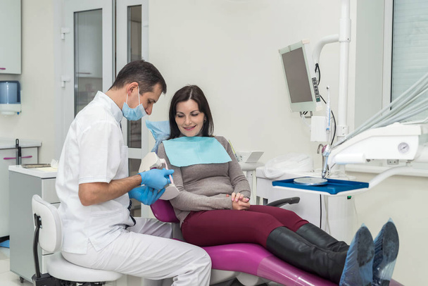 Patientin spricht mit Zahnarzt über Mundhygiene - Foto, Bild