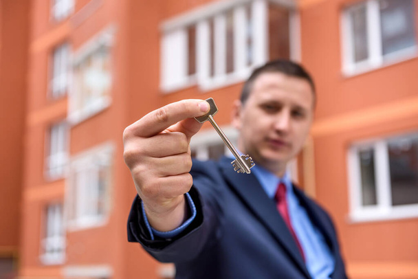 Broker with key from new apartment near new house - Φωτογραφία, εικόνα