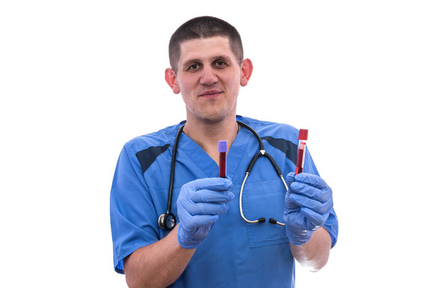 Chemist holding red test tubes with some liquid substance. He's looking on it  - Photo, Image