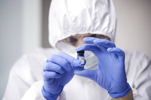 Technician holding an ampule with coronavirus cure - Valokuva, kuva