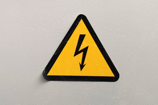 nagyfeszültségű figyelmeztető tábla szürke alapon - Fotó, kép