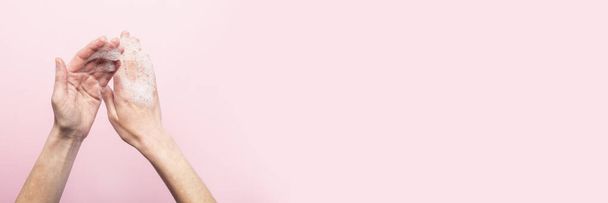 Lavarse las manos. Manos femeninas jabonosas sobre un fondo rosa. Concepto de las reglas de lavado y manipulación de manos. Vista superior, cama plana. Baner.
. - Foto, imagen