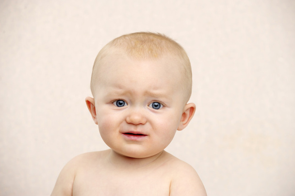 Baby looking at the camera on a peach background - Fotografie, Obrázek
