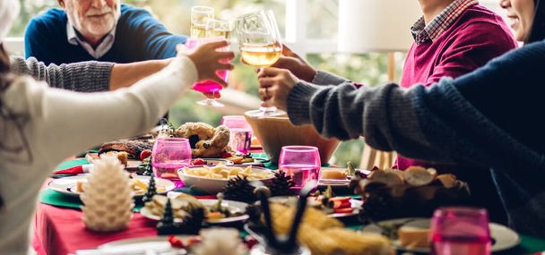 Portret van een gelukkig groot gezin vieren plezier en lunch samen, het drinken van rode wijn en klinkende glazen genieten van tijd samen thuis doorbrengen - Foto, afbeelding