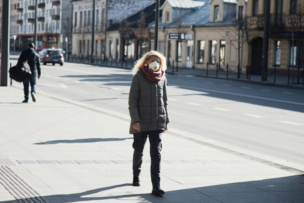 COVID-19 Pandemic Coronavirus Young girl in city street wearing face mask protective for spreading of Coronavirus Disease 2019. Close up of young woman with surgical mask on face against - Fotografie, Obrázek