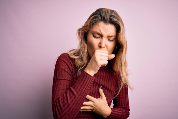 Young beautiful blonde woman wearing casual sweater over isolated pink background feeling unwell and coughing as symptom for cold or bronchitis. Health care concept. - Photo, Image