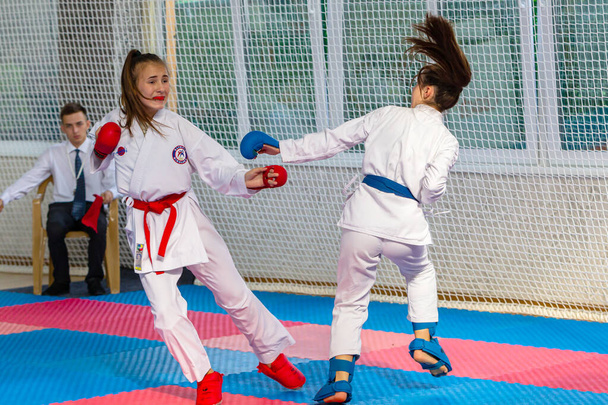 Odessa, Oekraïne - 30 september 2019: Karatekampioenschap onder kinderen van atleten. De beste karate vechters kinderen meisjes demonstreren hun vermogen om te vechten op tatami. Slag van karate jonge meisjes - Foto, afbeelding