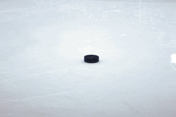 Μαύρο παλιό δίσκο χόκεϊ επί πάγου στο παγοδρόμιο. Έδρα της Λετονίας. - Φωτογραφία, εικόνα