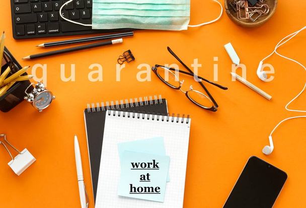 Coronavirus Covid -19 quarantine concept. Stay at home, work at home. Office desk top view on orange background. - Foto, Bild
